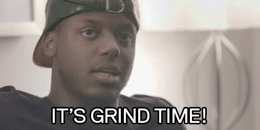 Young man with serious expression, text 'IT'S GRIND TIME!', cap backwards, determined look