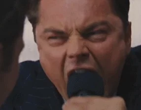 Leonardo DiCaprio screaming aggressively into microphone, extreme close-up, Wolf of Wall Street, raw intensity