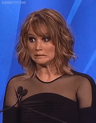 Jennifer Lawrence at podium with shocked/confused expression, blinking in disbelief, ELEMENTOFCRIME watermark, award show