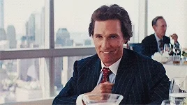 Matthew McConaughey at restaurant, knowing/approving smile, Wolf of Wall Street scene
