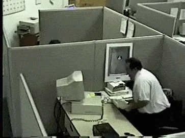 Office worker smashing his computer monitor on his desk in rage, cubicle setting, classic rage moment caught on camera