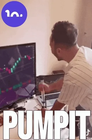 Trader pumps fist celebrating green candles on screens