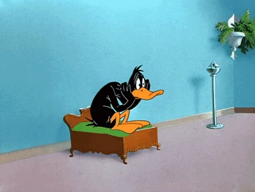 Daffy Duck assis, impatient/ennuyé — attente, impatience