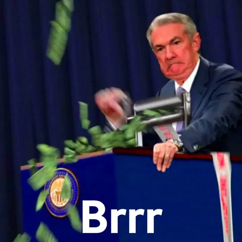 Jerome Powell at Federal Reserve podium operating a money printer shooting dollar bills everywhere, text 'Brrr' at the bottom, classic money printer go brrr meme