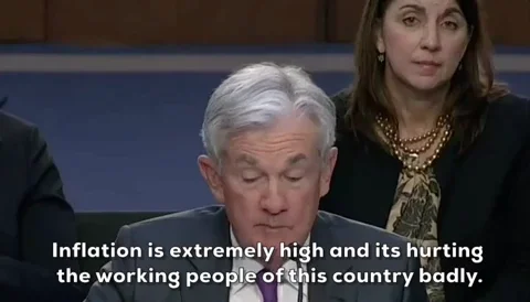 Jerome Powell at Congress hearing, subtitle 'Inflation is extremely high and its hurting the working people of this country badly.', somber expression