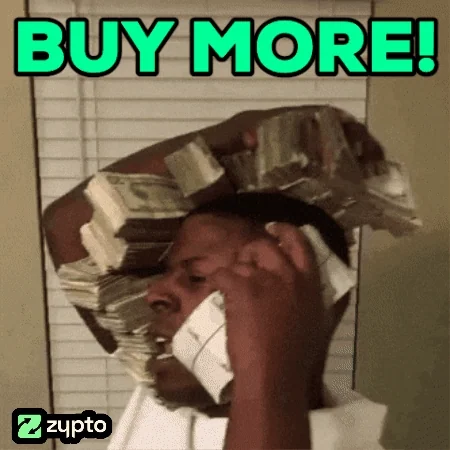 Man with stacks of cash piled on his head and hands, text 'BUY MORE!' in green, Zypto watermark, FOMO energy