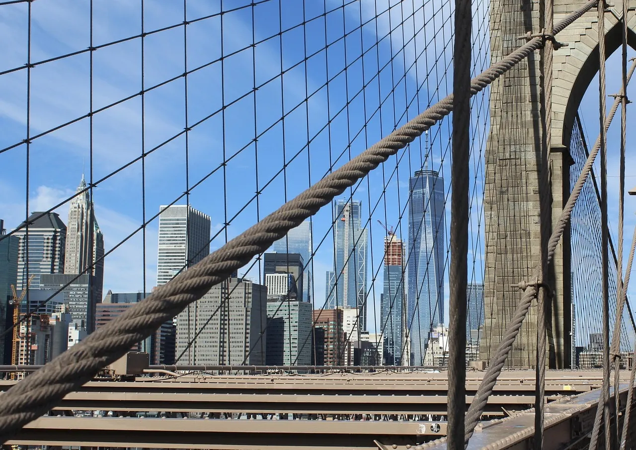 A view of the New York City skyline through the cables of the Brooklyn Bridge.