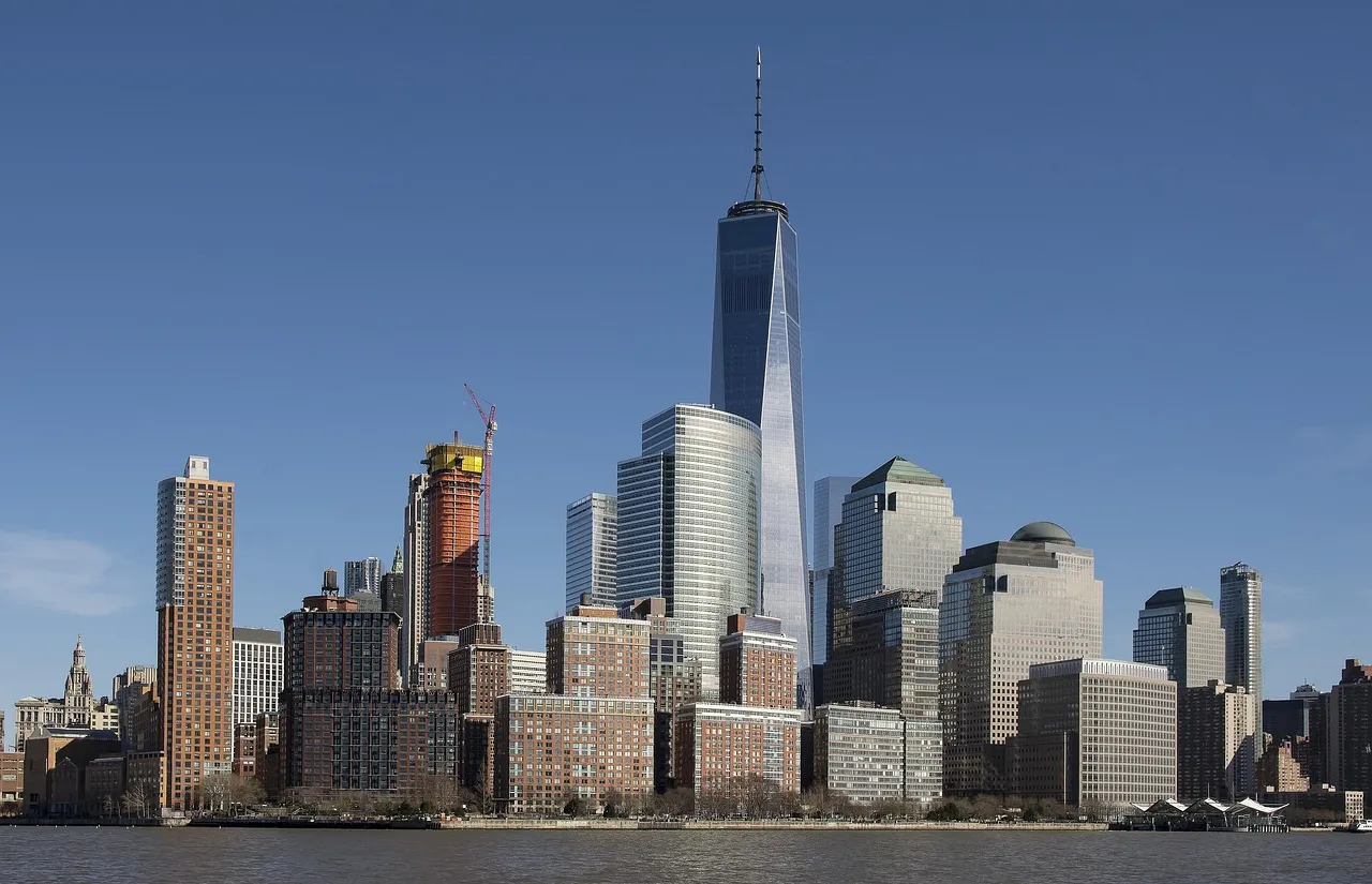 A panoramic view of the New York City skyline with One World Trade Center prominent.