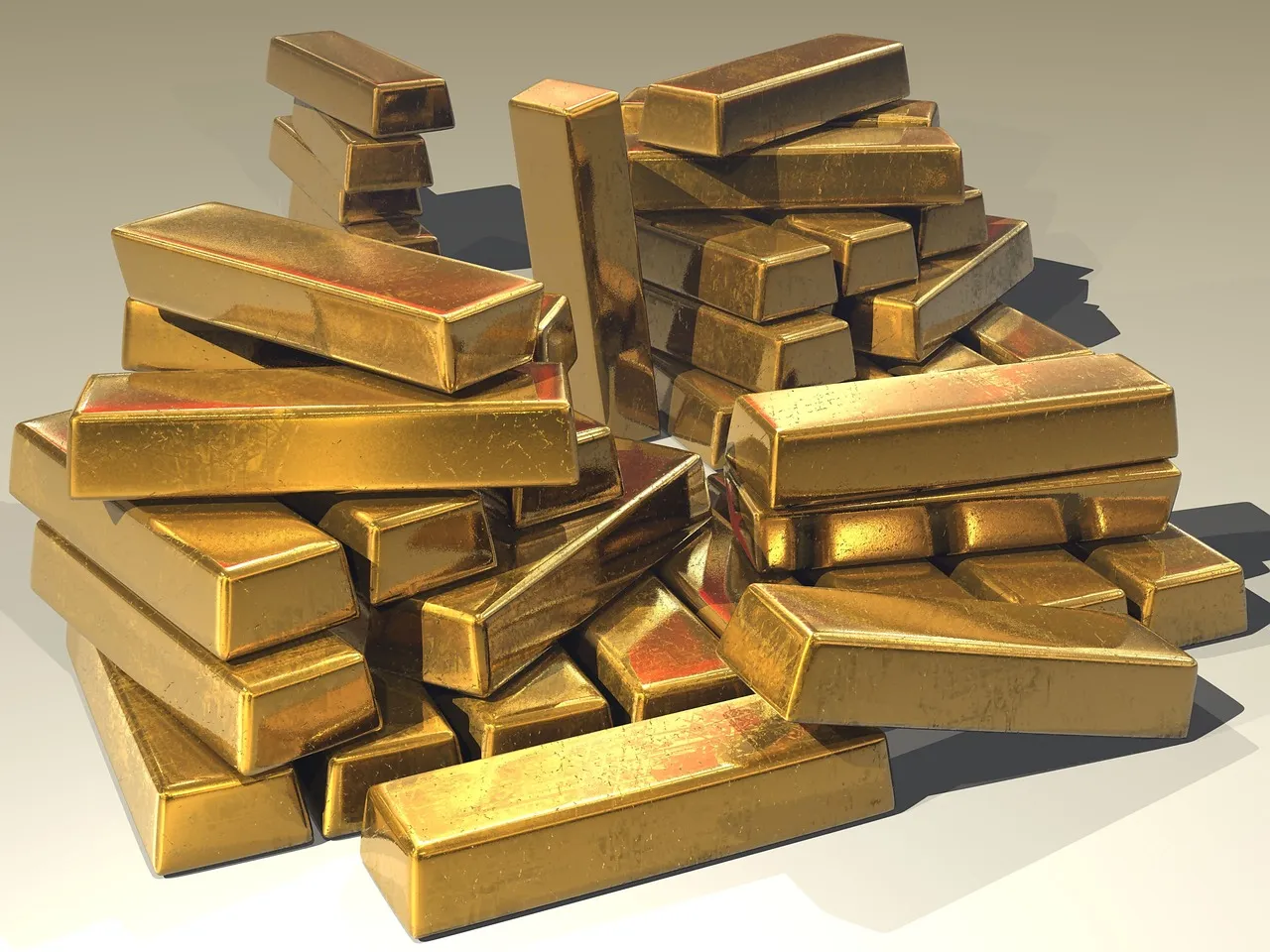 A large pile of shiny gold bars is scattered and stacked on a light surface.