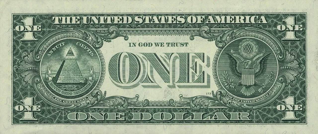 The reverse side of a US one-dollar bill, featuring the Great Seal and "IN GOD WE TRUST."