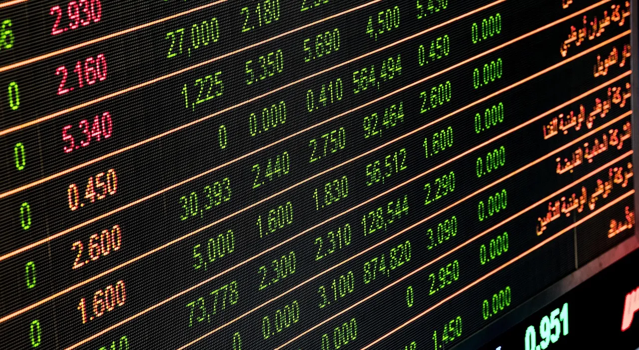 A close-up, angled shot of a digital stock market ticker displaying numbers and Arabic text.