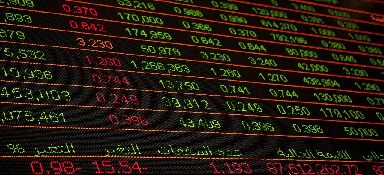 A close-up of a digital stock market ticker displaying numbers in red and green.