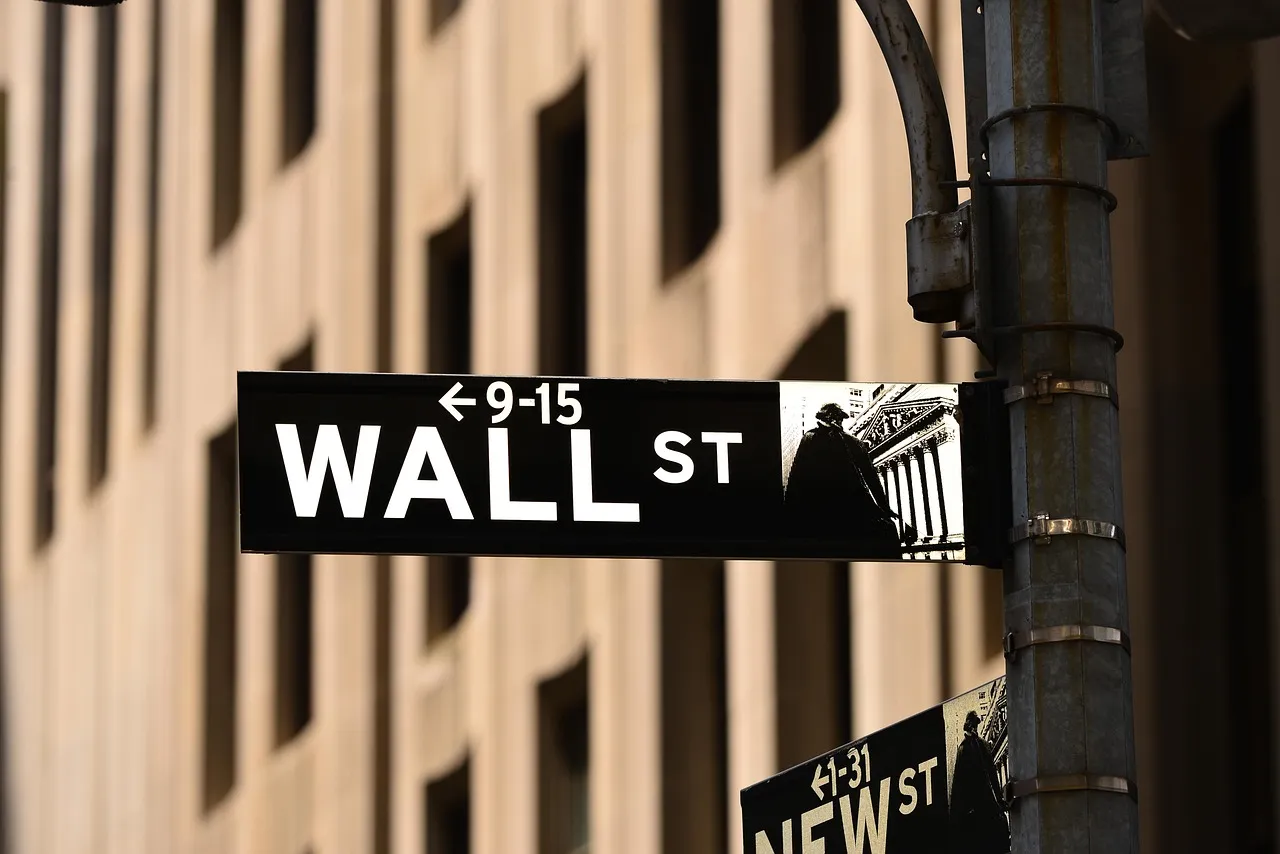 A Wall Street sign with an arrow pointing left to numbers 9-15, and an image of a building.